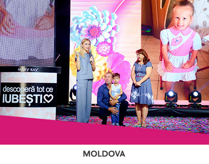 Mary Kay Moldova employees presenting funds on stage to a sick child in support of NGO Save A Life.